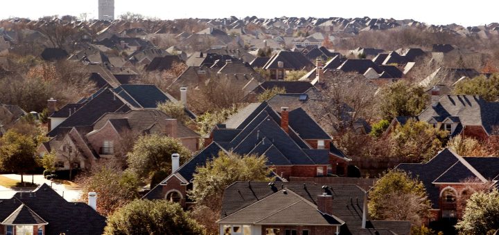 A McKinney water tower rises in the background over a sea of suburban rooftops of...